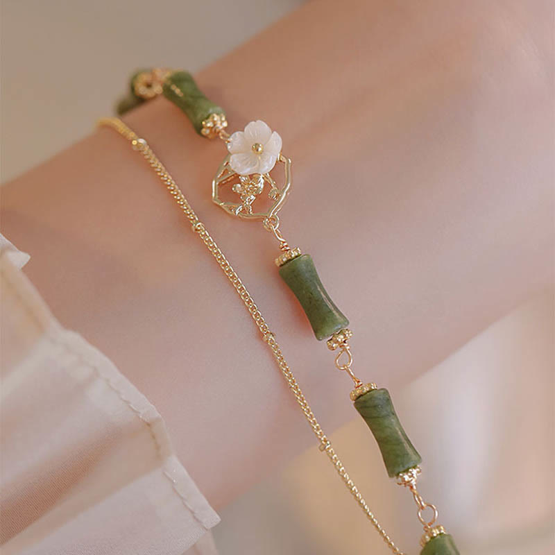 Bracciale Buddha Stones in rame placcato oro 14k con fiore di bambù, peridoto e doppio strato di ricchezza