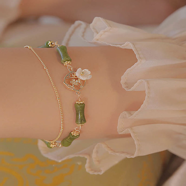 Bracciale Buddha Stones in rame placcato oro 14k con fiore di bambù, peridoto e doppio strato di ricchezza