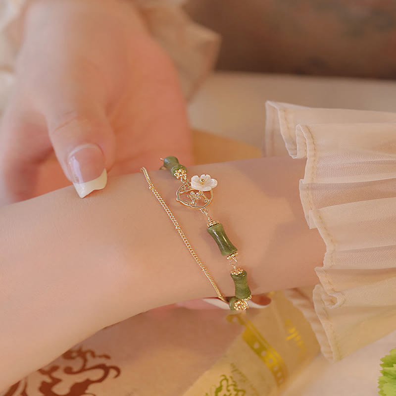 Bracciale Buddha Stones in rame placcato oro 14k con fiore di bambù, peridoto e doppio strato di ricchezza