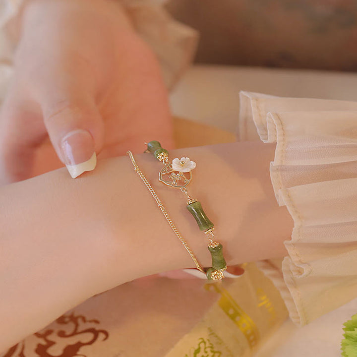Bracciale Buddha Stones in rame placcato oro 14k con fiore di bambù, peridoto e doppio strato di ricchezza