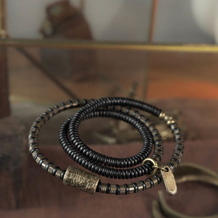 Braccialetto multistrato in rame con perline di legno di ebano tibetano e Buddha Stones