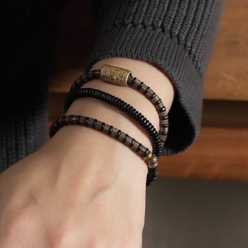 Braccialetto multistrato in rame con perline di legno di ebano tibetano e Buddha Stones