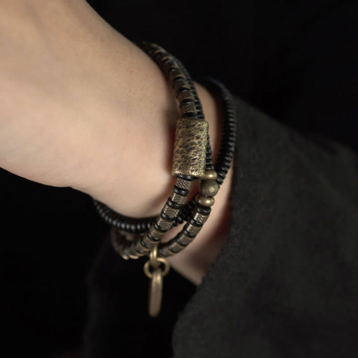 Braccialetto multistrato in rame con perline di legno di ebano tibetano e Buddha Stones