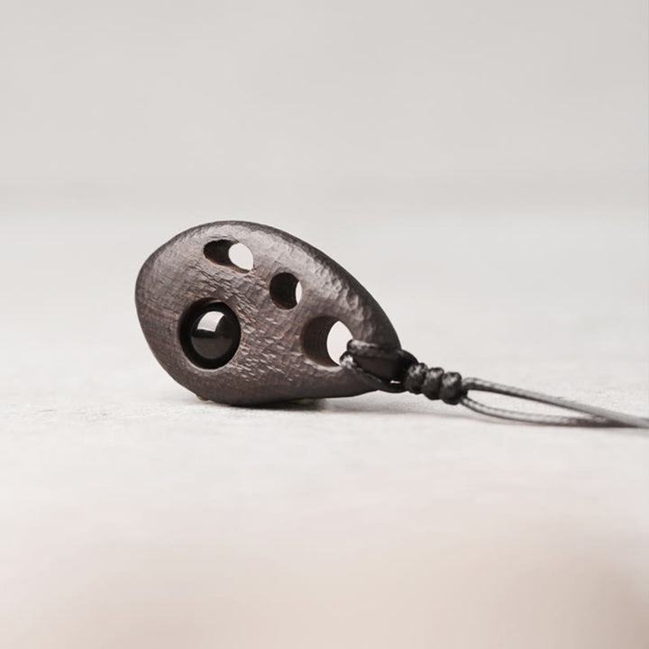 Collana con ciondolo in ossidiana intarsiata cava in legno di ebano Buddha Stones, pace e calma