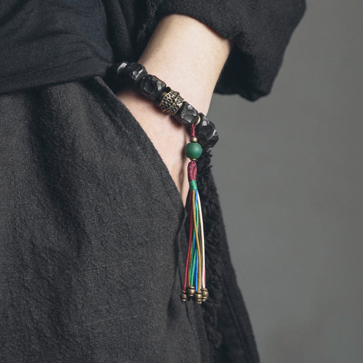 Bracciale Mala da polso con nappa in legno di Buddha Stones tibetano e rame della pace