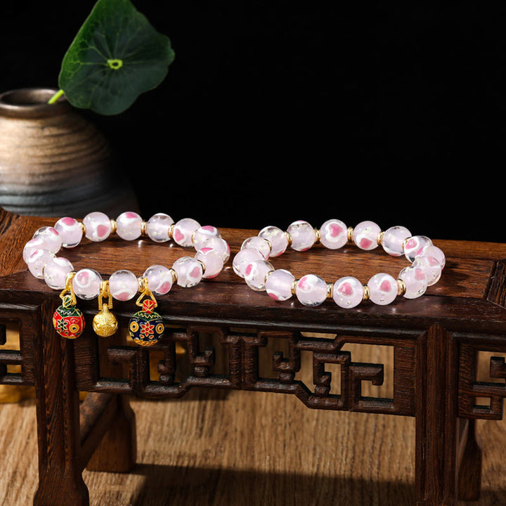 Braccialetto di perline di vetro fluorescente luminoso Liuli con cuore rosa della famiglia di bestie che ingoiano Buddha Stones