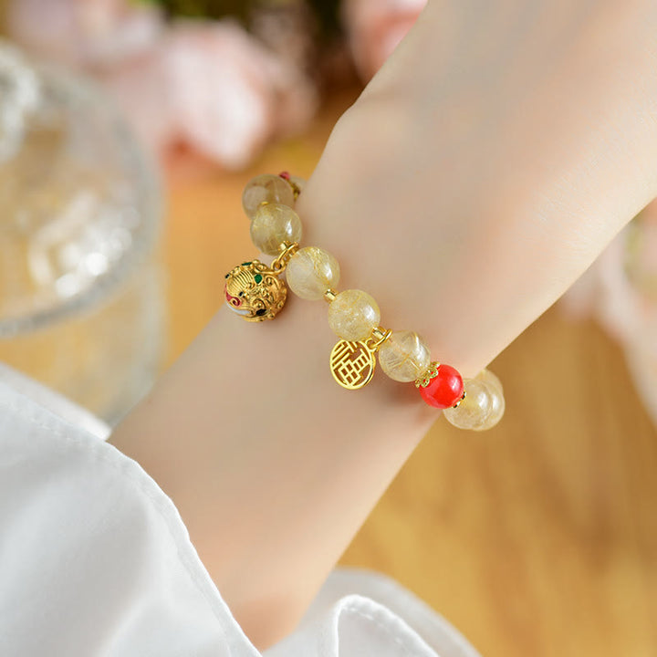 Braccialetto di ricchezza con ciondolo a forma di campana con carattere Fu in quarzo rutilato dorato naturale Buddha Stones