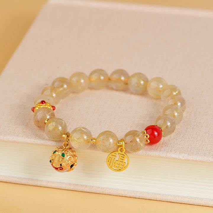 Braccialetto di ricchezza con ciondolo a forma di campana con carattere Fu in quarzo rutilato dorato naturale Buddha Stones