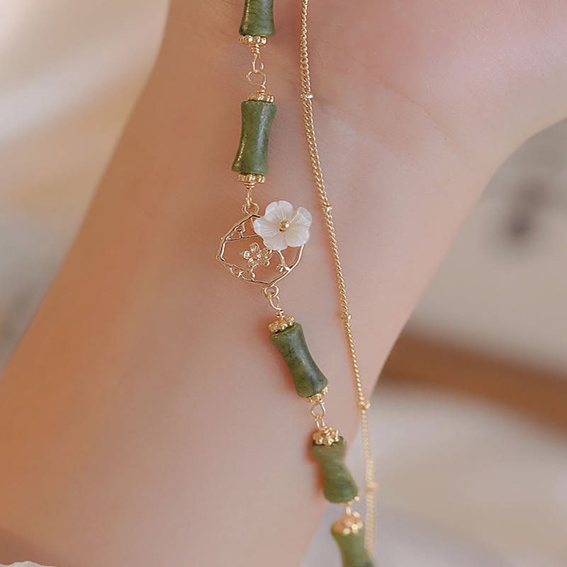 Bracciale Buddha Stones in rame placcato oro 14k con fiore di bambù, peridoto e doppio strato di ricchezza