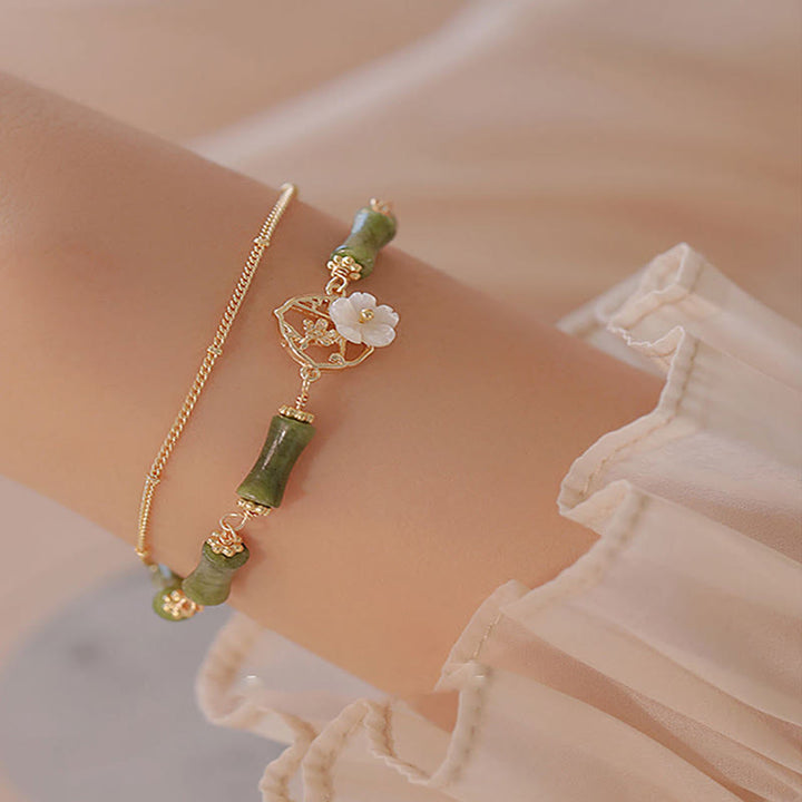 Bracciale Buddha Stones in rame placcato oro 14k con fiore di bambù, peridoto e doppio strato di ricchezza