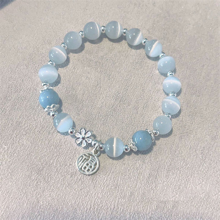 Braccialetto di supporto con ciondolo a forma di carattere Fu con campanella in fiore di pesco e cristalli occhio di gatto Buddha Stones