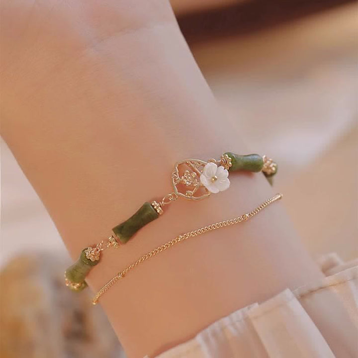 Bracciale Buddha Stones in rame placcato oro 14k con fiore di bambù, peridoto e doppio strato di ricchezza