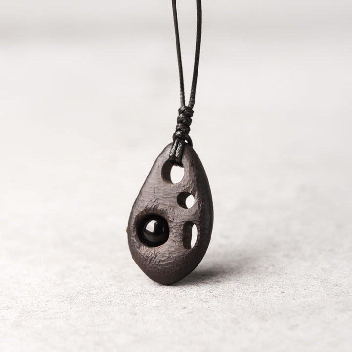 Collana con ciondolo in ossidiana intarsiata cava in legno di ebano Buddha Stones, pace e calma
