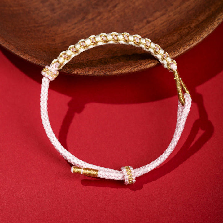 Bracciale intrecciato con nodo di collegamento in fili d'oro tibetani con pietre Buddha Stones e fiori di pesco colorati