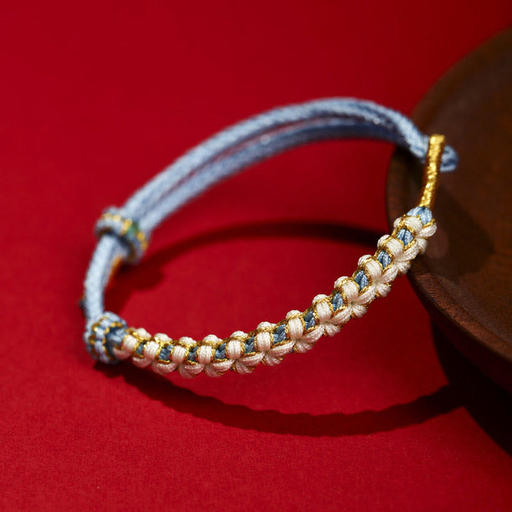 Bracciale intrecciato con nodo di collegamento in fili d'oro tibetani con pietre Buddha Stones e fiori di pesco colorati