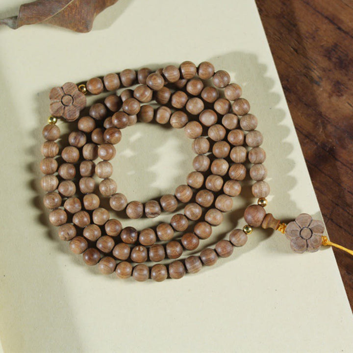 Bracciale Mala di guarigione con ciondolo in legno di sandalo e fiori di prugna Buddha Stones