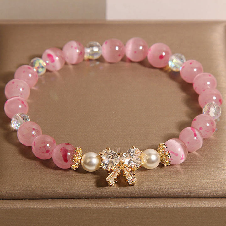 Braccialetto di supporto con fiocco e rosetta, in perle occhio di gatto rosa e fiori di ciliegio Buddha Stones