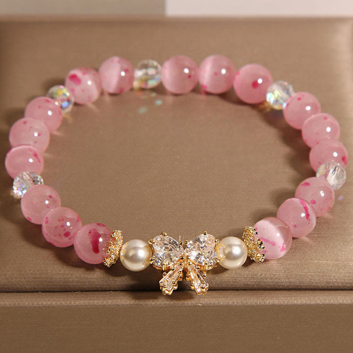 Braccialetto di supporto con fiocco e rosetta, in perle occhio di gatto rosa e fiori di ciliegio Buddha Stones