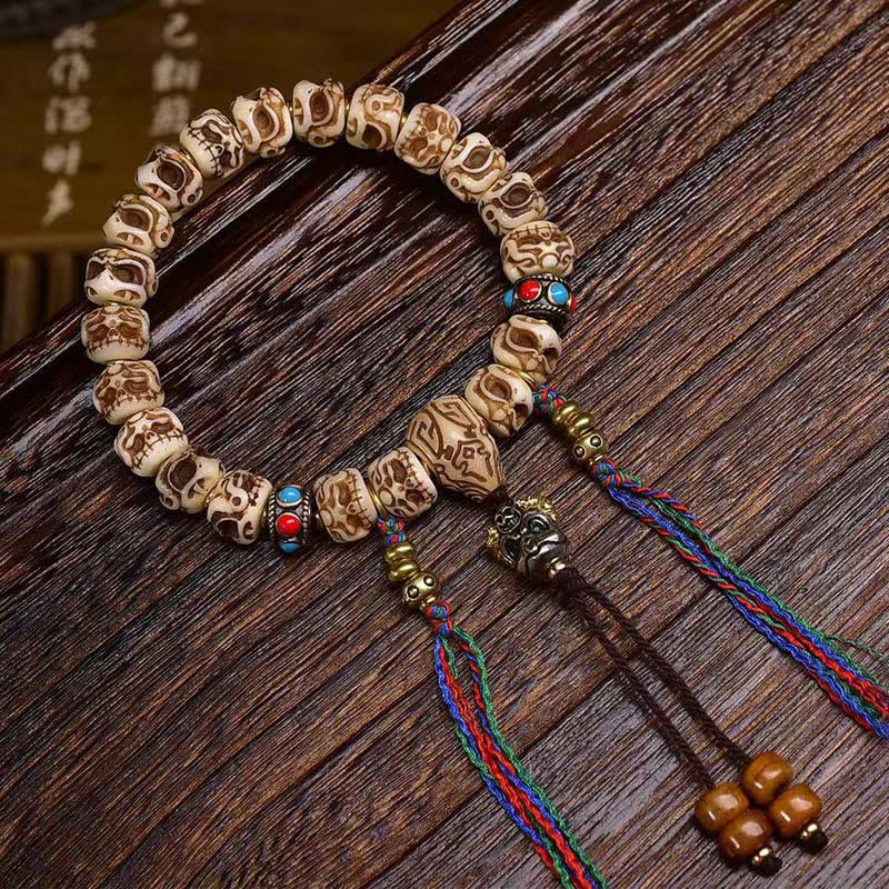 Braccialetto di protezione con nappa intagliata in osso di cammello Buddha Stones e Garuda