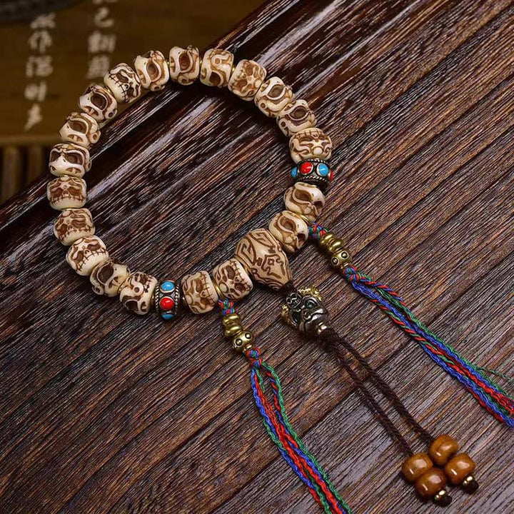 Braccialetto di protezione con nappa intagliata in osso di cammello Buddha Stones e Garuda