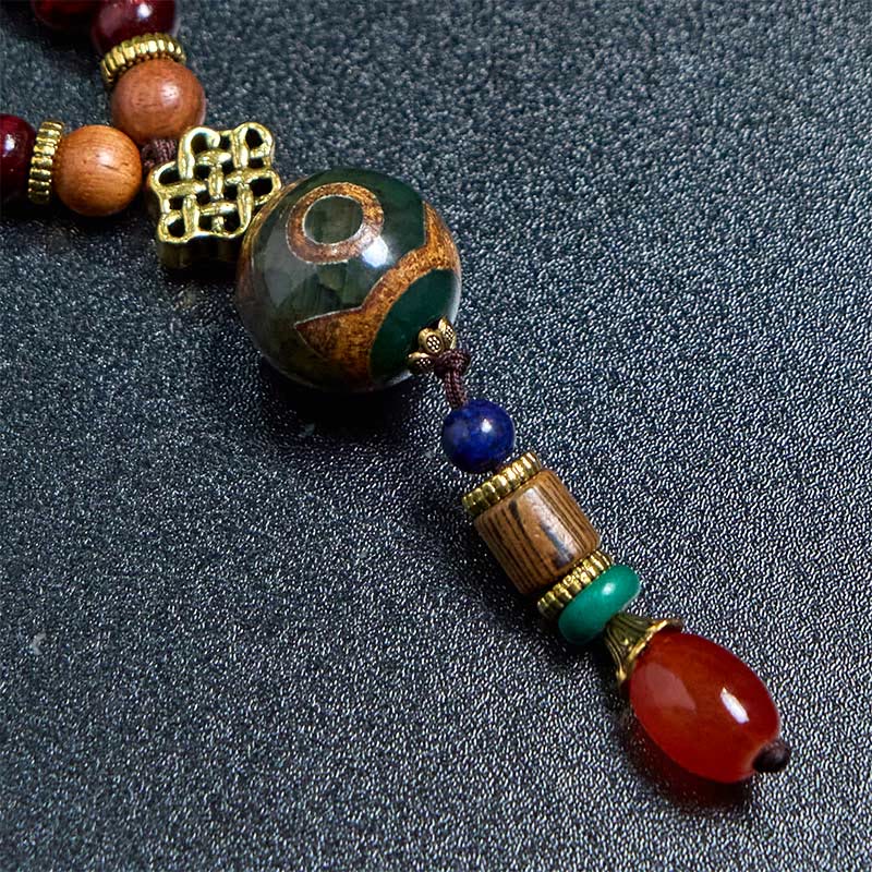 Collana con ciondolo a forma di testa di elefante, in legno wengé, fatto a mano in Tibet, con perline Dzi di protezione.
