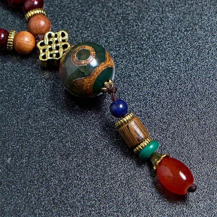 Collana con ciondolo a forma di testa di elefante, in legno wengé, fatto a mano in Tibet, con perline Dzi di protezione.