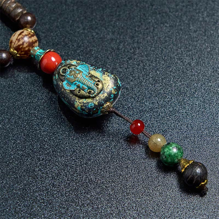 Collana con ciondolo a forma di testa di elefante, in legno wengé, fatto a mano in Tibet, con perline Dzi di protezione.