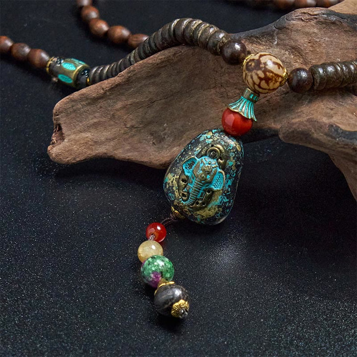 Collana con ciondolo a forma di testa di elefante, in legno wengé, fatto a mano in Tibet, con perline Dzi di protezione.