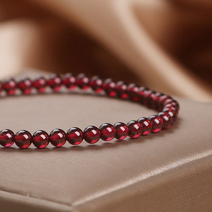 Bracciale Buddha Stones con perle di granato naturale da 4 mm e fiore della passione