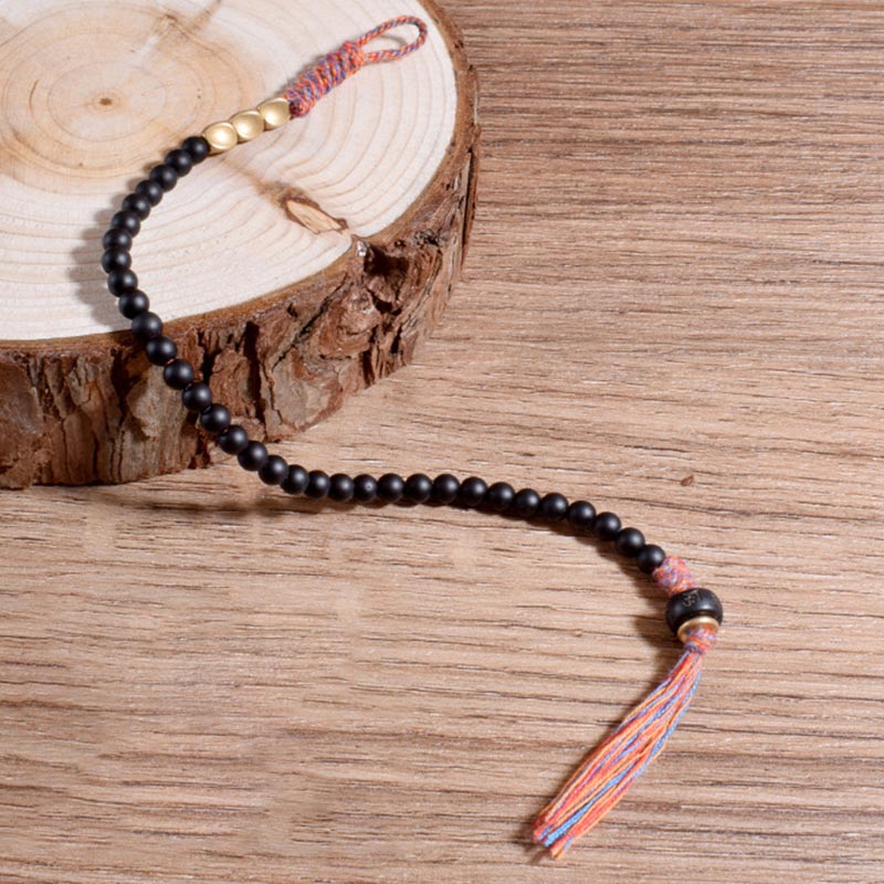 Braccialetto fatto a mano in onice nero tibetano con nappa Buddha Stones