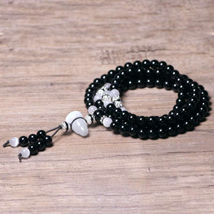 Braccialetto di meditazione con perline di cristallo bianco e onice nero Buddha Stones