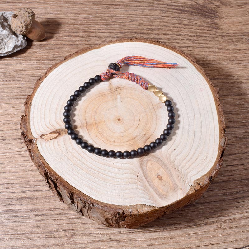 Braccialetto fatto a mano in onice nero tibetano con nappa Buddha Stones