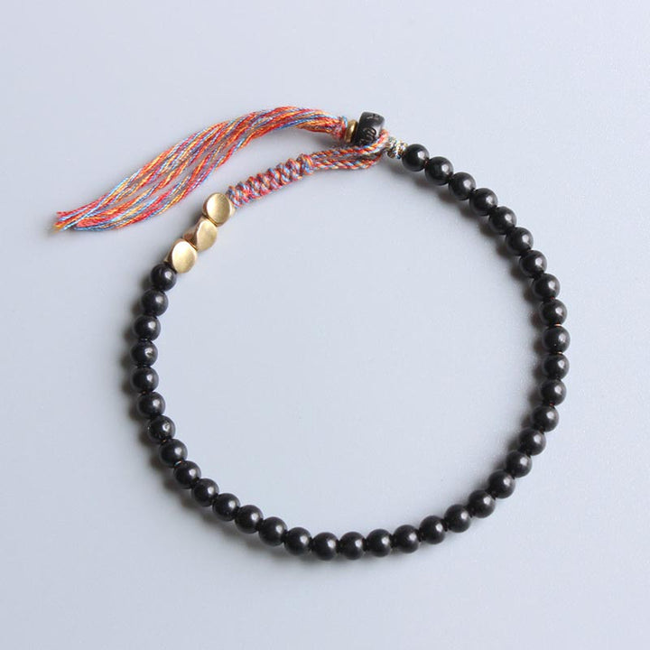 Braccialetto fatto a mano in onice nero tibetano con nappa Buddha Stones