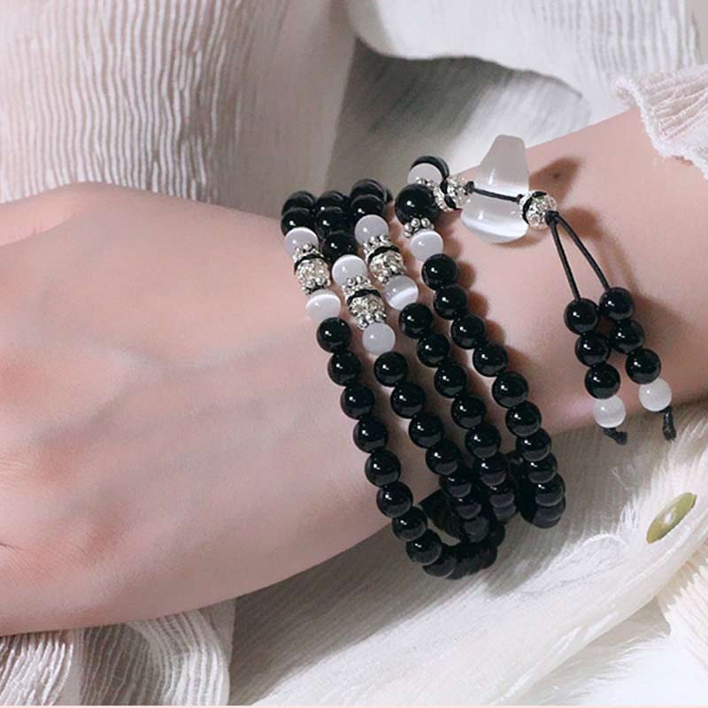 Braccialetto di meditazione con perline di cristallo bianco e onice nero Buddha Stones