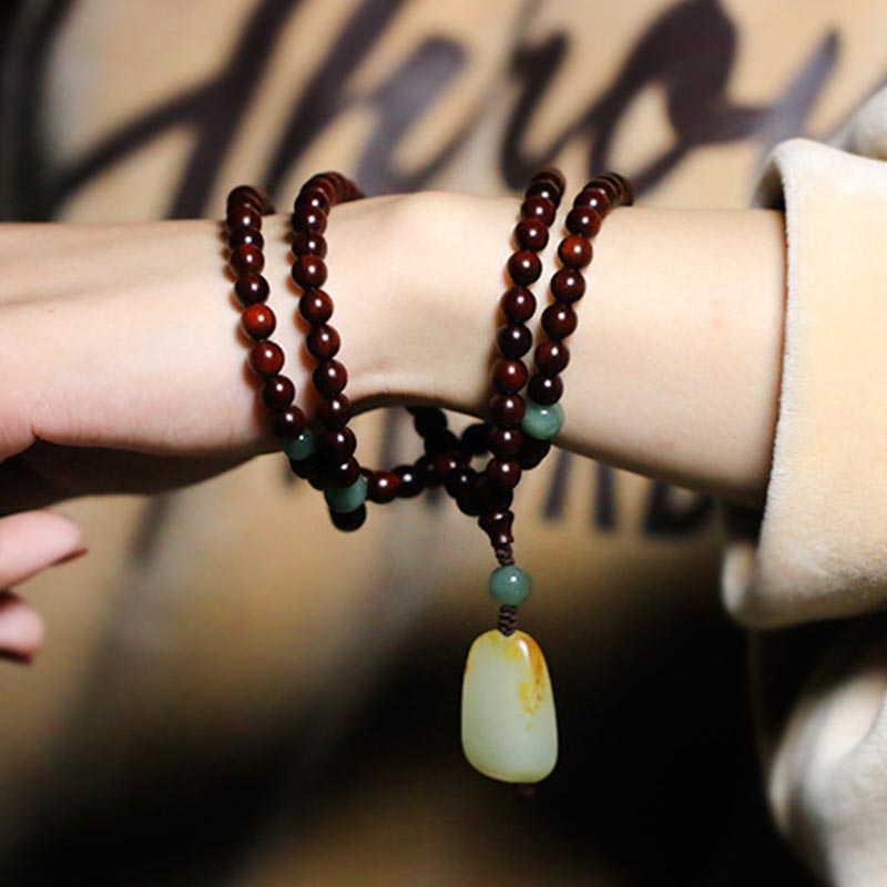 Braccialetto di meditazione Mala in giada di sandalo rosso con piccole foglie tibetane di Buddha Stones