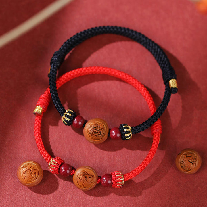 Braccialetto della ricchezza in cinabro intagliato con carattere dello zodiaco cinese Fu in legno di pesca naturale Buddha Stones