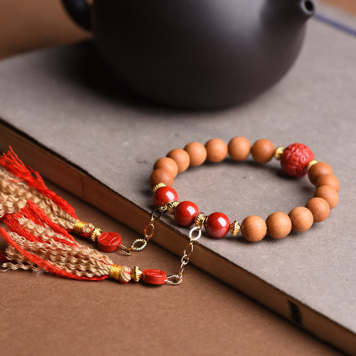 Braccialetto con nappe di ricchezza in legno di pesca naturale tibetano di cinabro PiXiu Buddha Stones