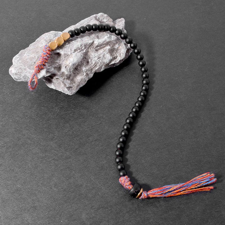 Braccialetto fatto a mano in onice nero tibetano con nappa Buddha Stones