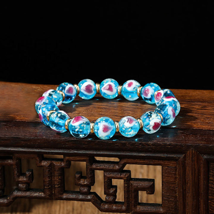 Braccialetto di perline di vetro fluorescente luminoso Liuli con cuore rosa della famiglia di bestie che ingoiano Buddha Stones