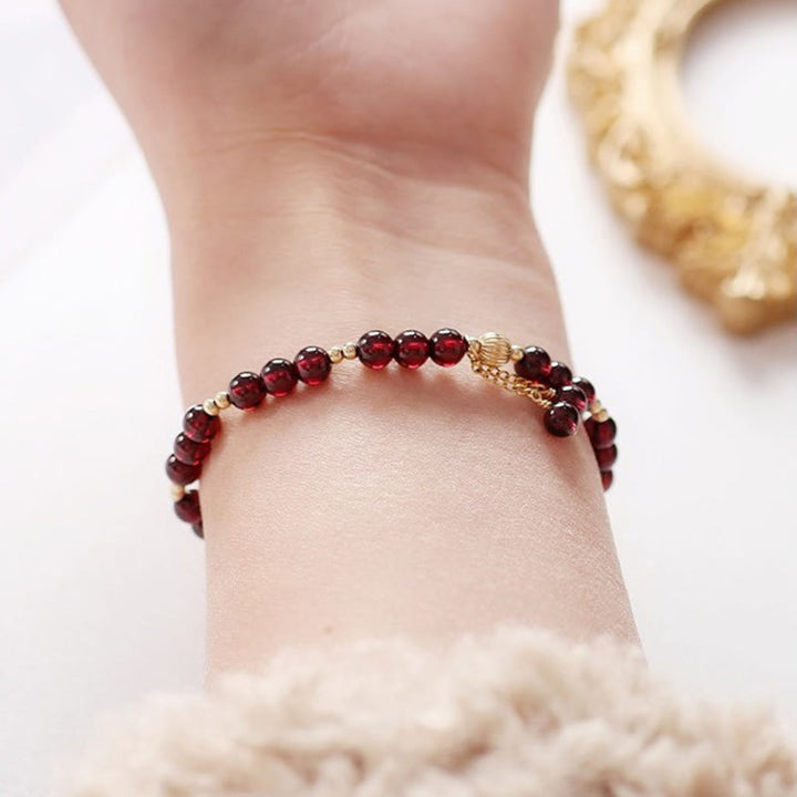 Bracciale Buddha Stones in oro 14K con granato naturale e calma