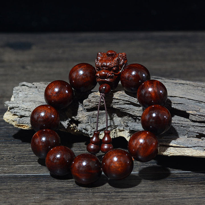 Braccialetto di protezione intagliato a forma di drago con piccole foglie di sandalo rosso, in palissandro e sandalo verde Buddha Stones