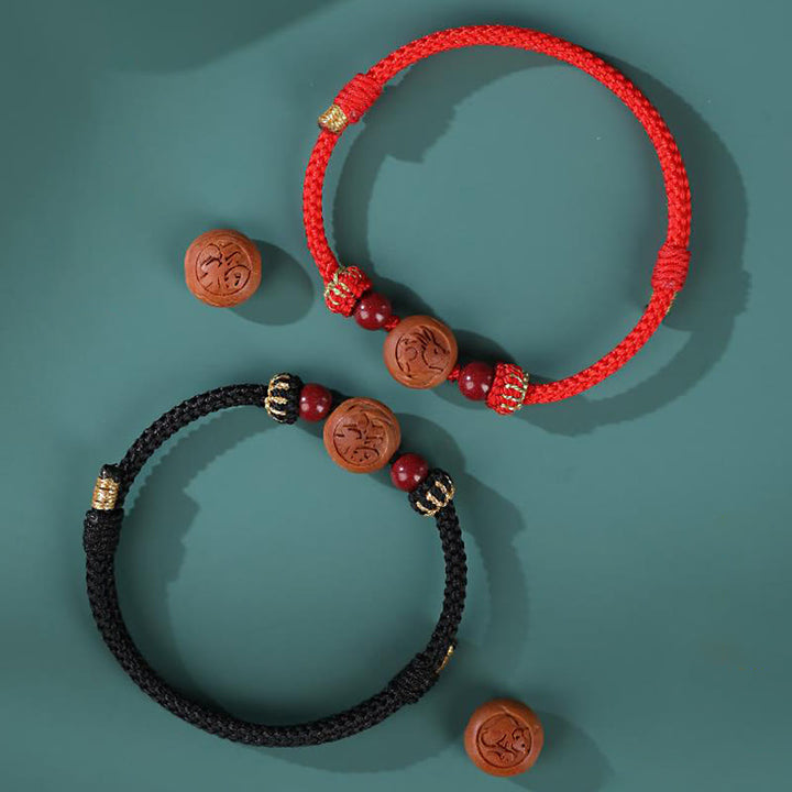 Braccialetto della ricchezza in cinabro intagliato con carattere dello zodiaco cinese Fu in legno di pesca naturale Buddha Stones
