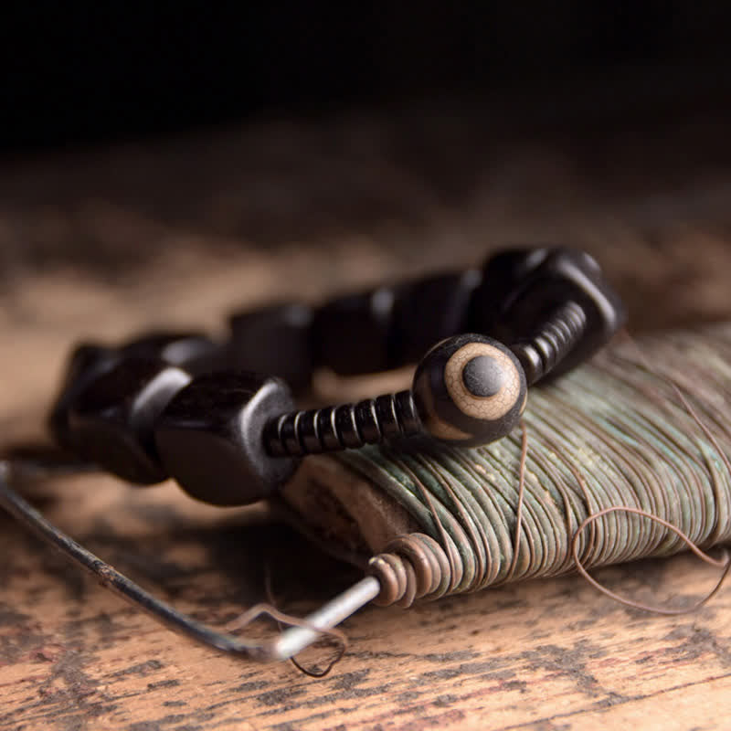 Braccialetto di forza con perline di legno di ebano tibetano Dzi Buddha Stones