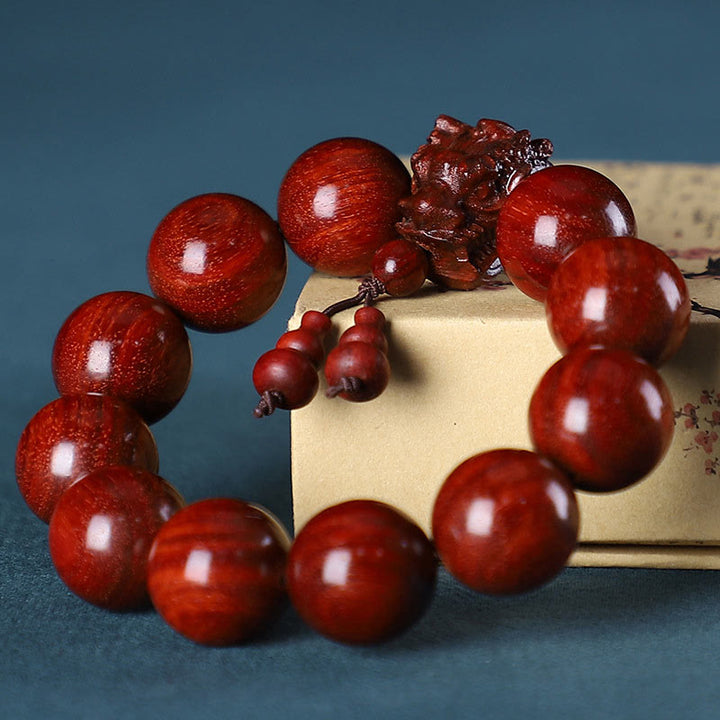 Braccialetto di protezione intagliato a forma di drago con piccole foglie di sandalo rosso, in palissandro e sandalo verde Buddha Stones