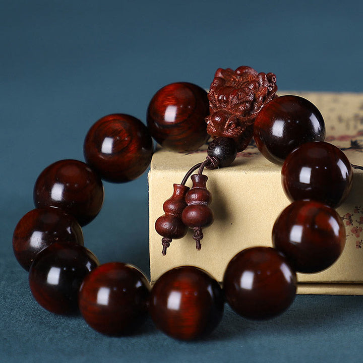 Braccialetto di protezione intagliato a forma di drago con piccole foglie di sandalo rosso, in palissandro e sandalo verde Buddha Stones