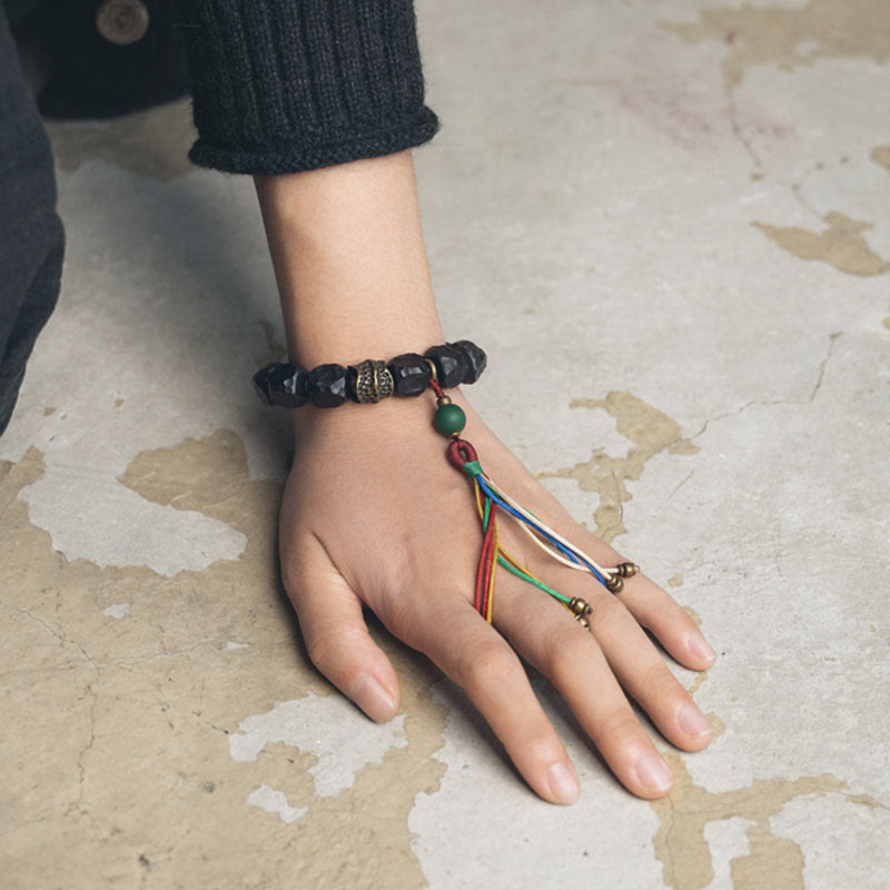 Bracciale Mala da polso con nappa in legno di Buddha Stones tibetano e rame della pace