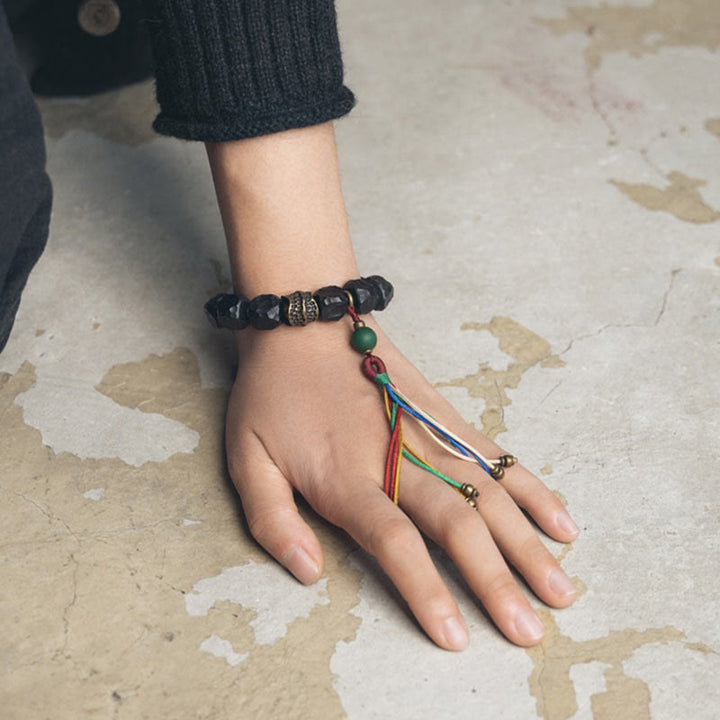 Bracciale Mala da polso con nappa in legno di Buddha Stones tibetano e rame della pace