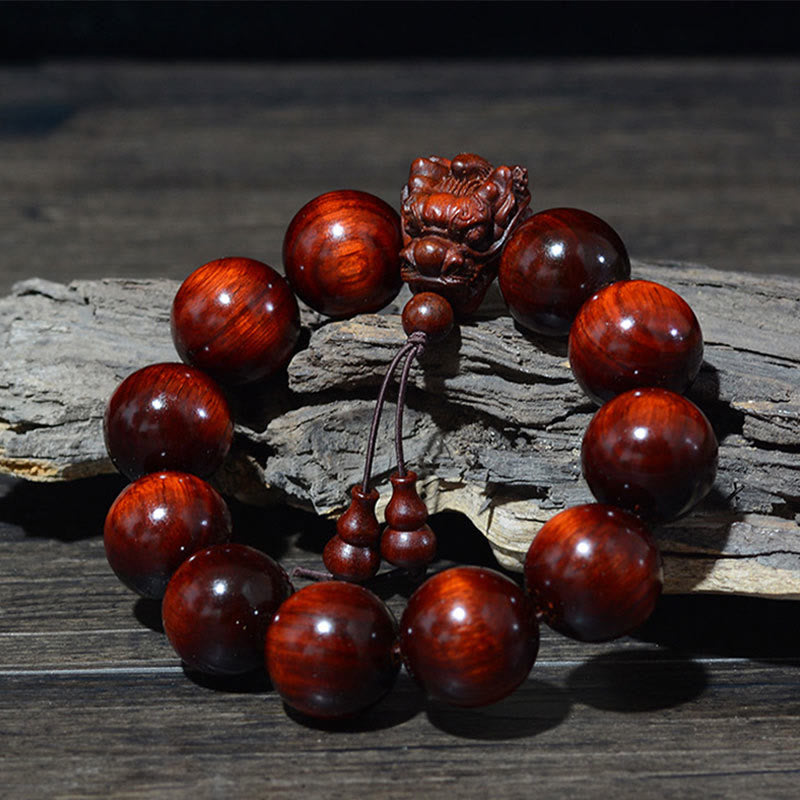 Braccialetto di protezione intagliato a forma di drago con piccole foglie di sandalo rosso, in palissandro e sandalo verde Buddha Stones