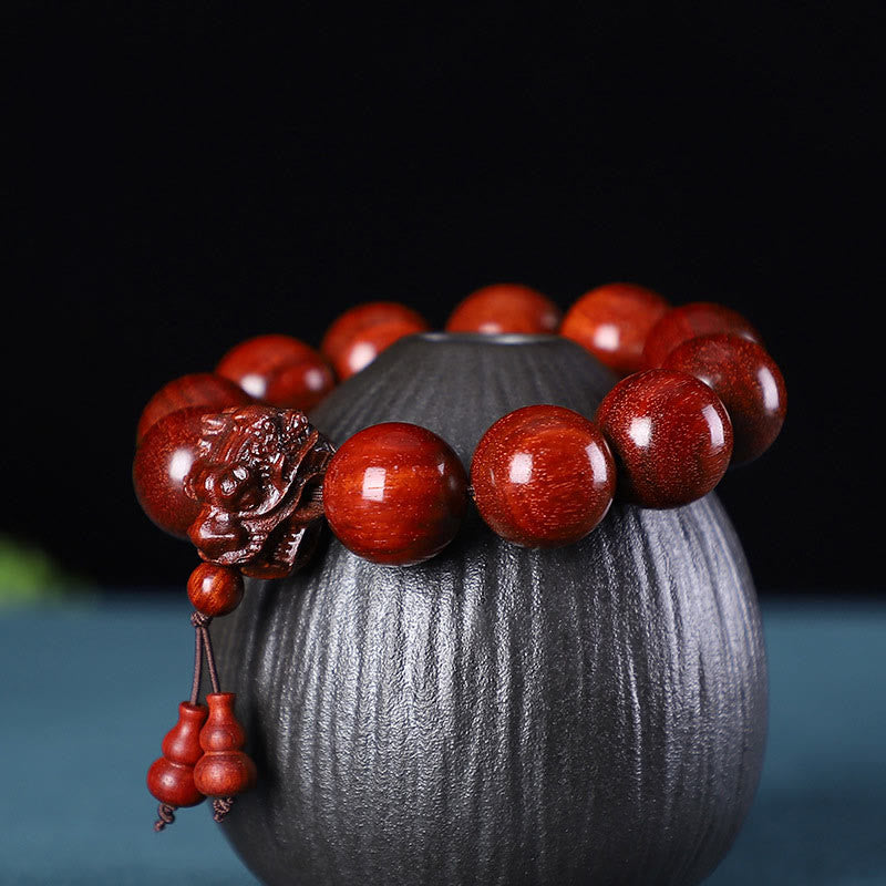 Braccialetto di protezione intagliato a forma di drago con piccole foglie di sandalo rosso, in palissandro e sandalo verde Buddha Stones