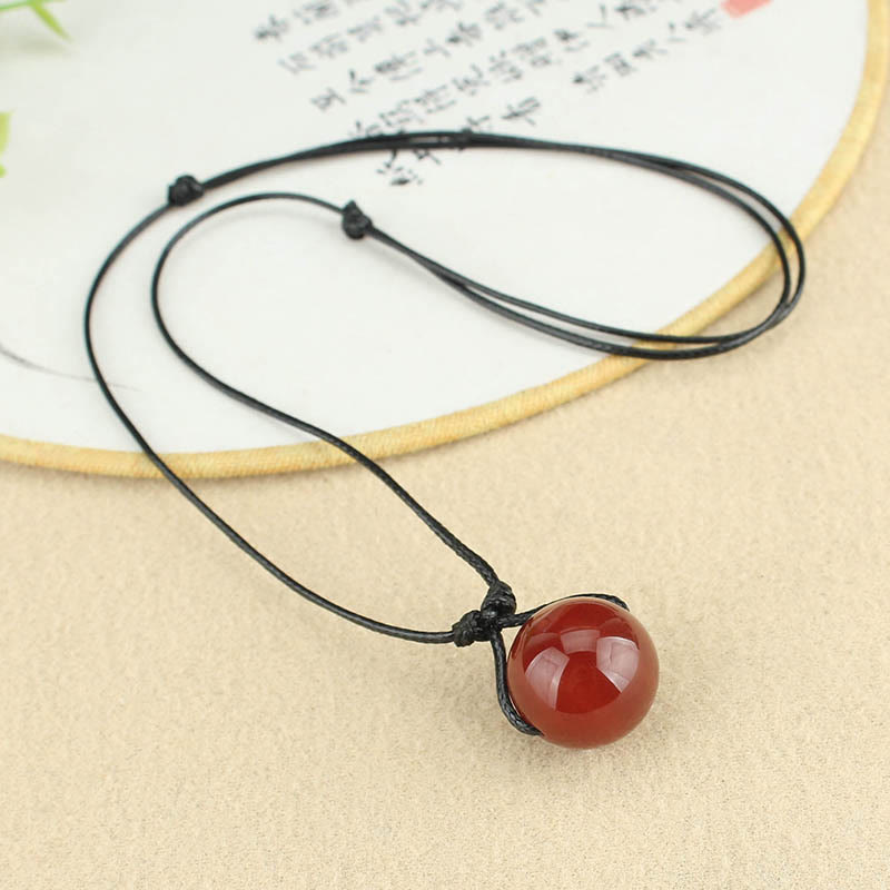Collana con ciondolo in corda di pelle con perline di agata rossa e Buddha Stones
